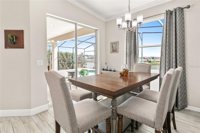 dining room featuring light wood-type flooring, a notable chandelier, crown molding, a sunroom, and baseboards