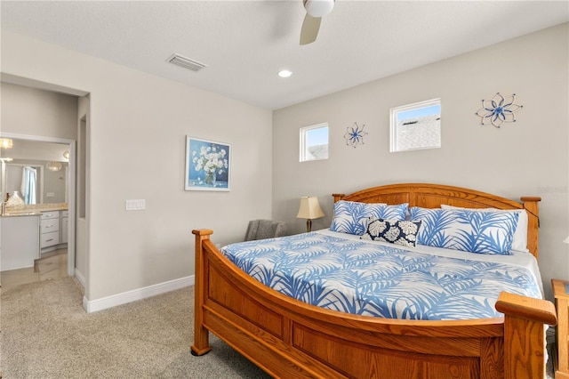 carpeted bedroom featuring visible vents, ceiling fan, ensuite bathroom, and baseboards