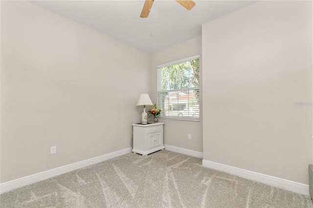 empty room featuring a ceiling fan, vaulted ceiling, carpet, and baseboards