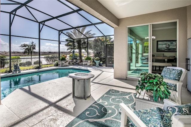 outdoor pool with a patio area, glass enclosure, and a water view