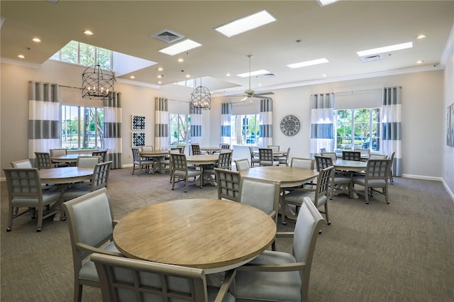 carpeted dining space with plenty of natural light, visible vents, and ornamental molding