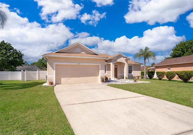 view of front of house featuring a front yard, an attached garage, fence, and stucco siding