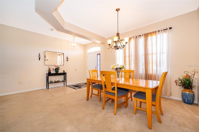 dining space featuring baseboards, a chandelier, and light carpet