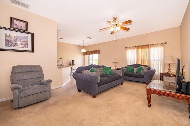 living room with light carpet, visible vents, plenty of natural light, and ceiling fan