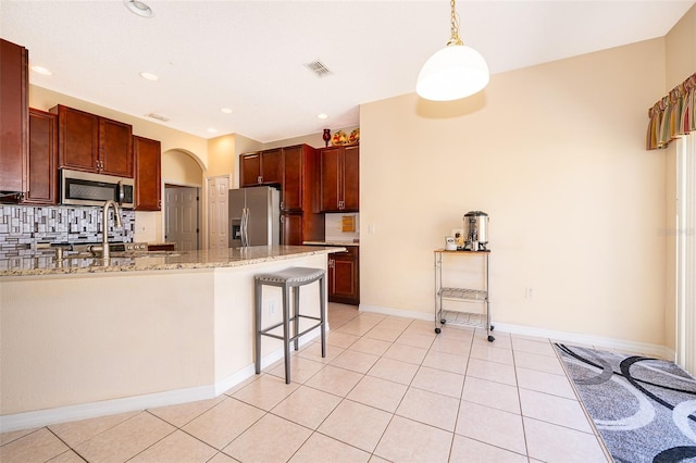 kitchen featuring light tile patterned floors, visible vents, a peninsula, decorative backsplash, and appliances with stainless steel finishes