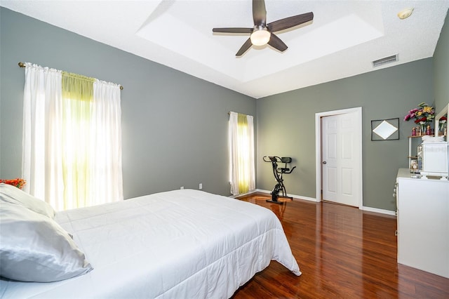 bedroom featuring visible vents, multiple windows, and a tray ceiling