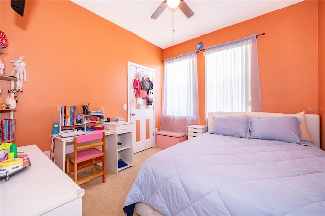 bedroom with a ceiling fan and light carpet