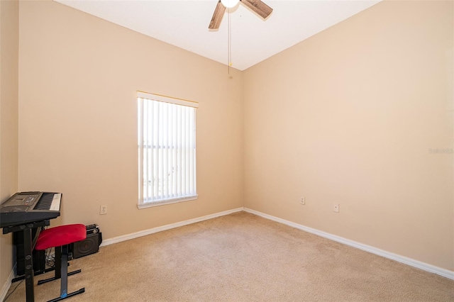 carpeted office featuring baseboards and a ceiling fan