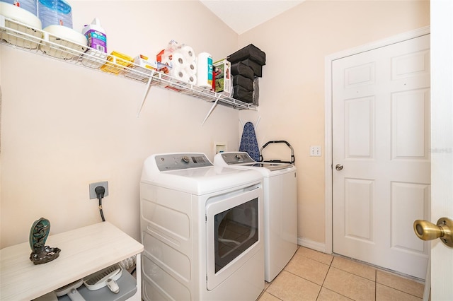 laundry area featuring light tile patterned floors, washing machine and dryer, and laundry area