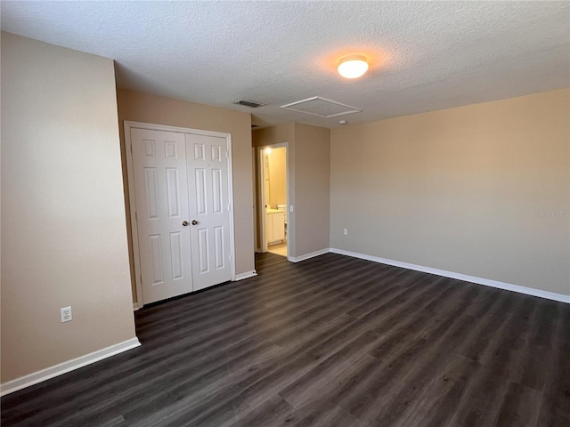 unfurnished bedroom featuring visible vents, baseboards, a closet, and dark wood-style flooring