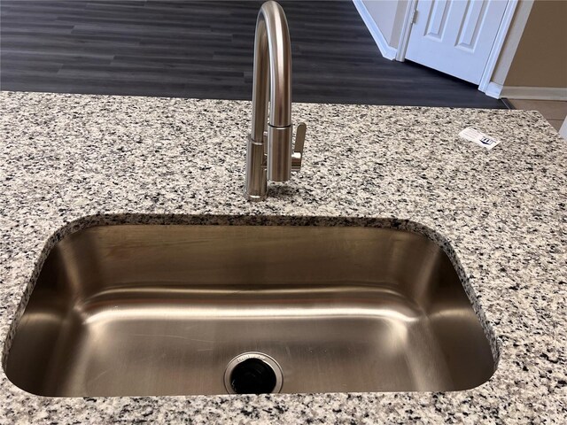 room details with a sink and light stone countertops