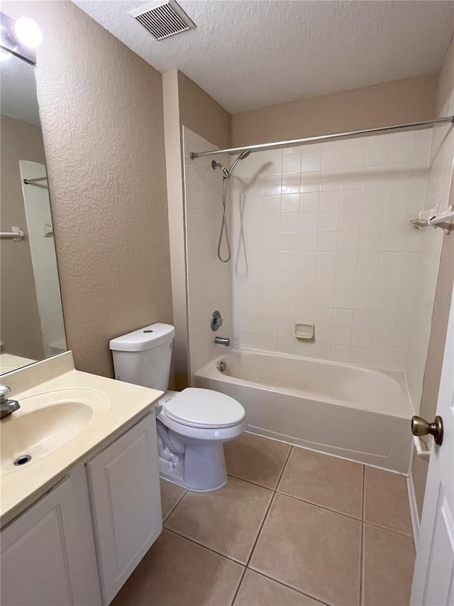 full bath featuring visible vents, toilet, shower / bathing tub combination, tile patterned floors, and a textured ceiling