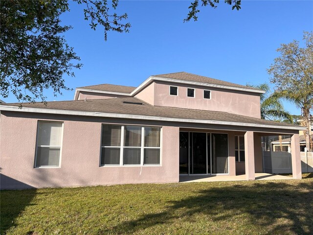 back of house with a yard, a patio area, fence, and stucco siding