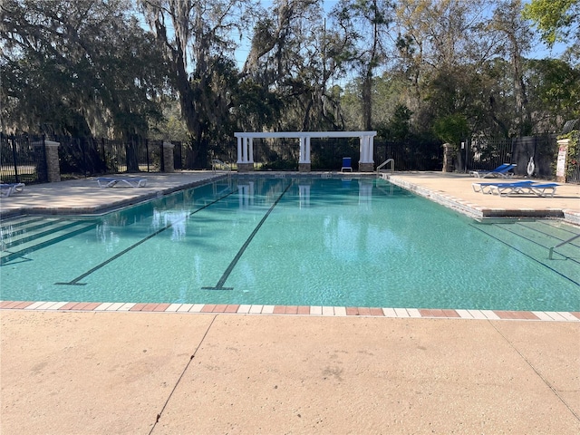 pool with a patio and fence