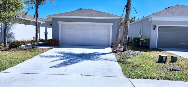 view of front of property featuring a shingled roof, a garage, driveway, and stucco siding