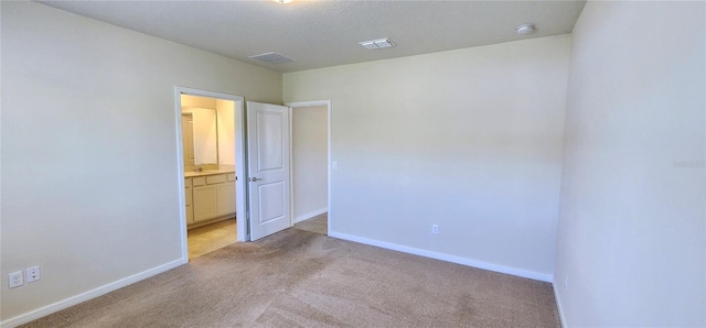 empty room with visible vents, baseboards, and light colored carpet