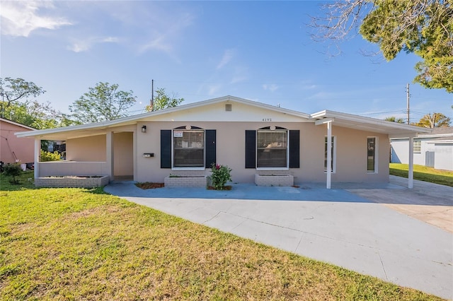 ranch-style house featuring stucco siding, driveway, an attached carport, and a front yard