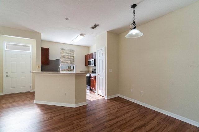 kitchen featuring dark wood-style floors, visible vents, baseboards, a peninsula, and appliances with stainless steel finishes