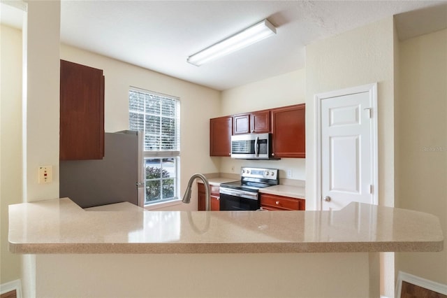 kitchen with a sink, a peninsula, and stainless steel appliances