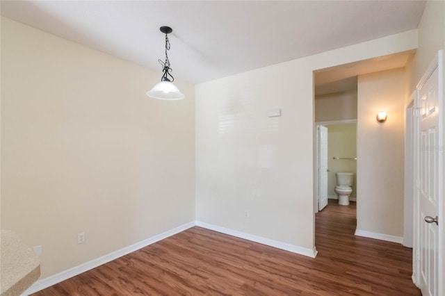 empty room with baseboards and wood finished floors