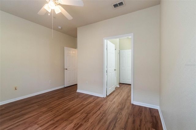 unfurnished bedroom featuring ceiling fan, wood finished floors, visible vents, and baseboards