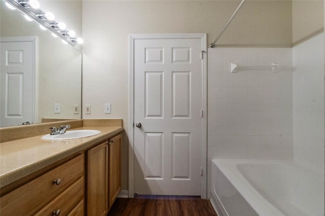 bathroom featuring shower / bathtub combination, wood finished floors, and vanity