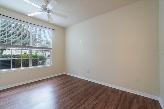 empty room featuring wood finished floors, baseboards, and ceiling fan