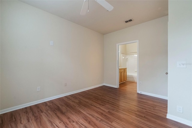 spare room with a ceiling fan, wood finished floors, visible vents, and baseboards