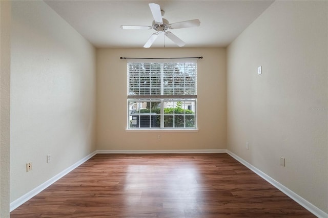 spare room featuring ceiling fan, baseboards, and wood finished floors