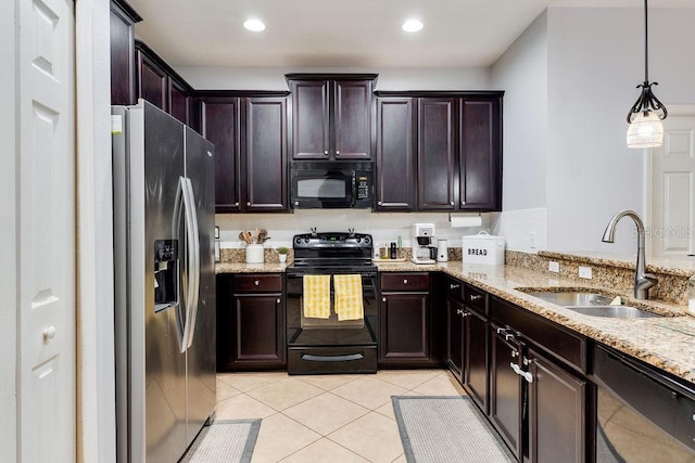 kitchen featuring light stone counters, light tile patterned floors, a sink, black appliances, and dark brown cabinetry