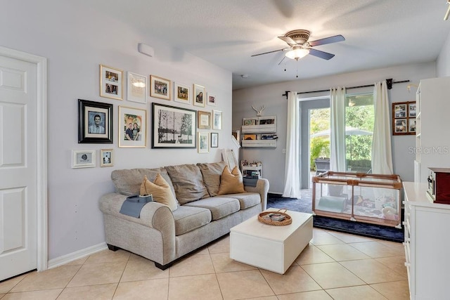 living area featuring light tile patterned flooring, baseboards, and a ceiling fan