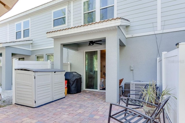 view of patio / terrace with grilling area, central AC, ceiling fan, and fence