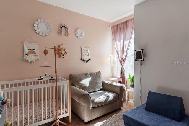 bedroom with a nursery area and carpet floors