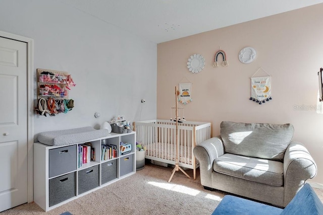 carpeted bedroom with a nursery area