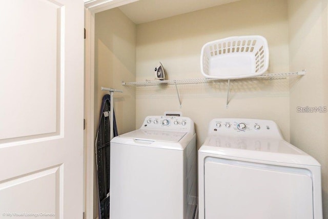 clothes washing area with separate washer and dryer and laundry area