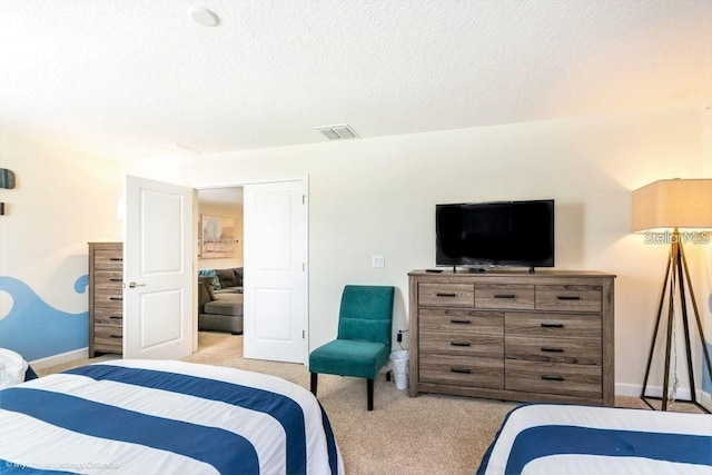 carpeted bedroom featuring visible vents, baseboards, and a textured ceiling