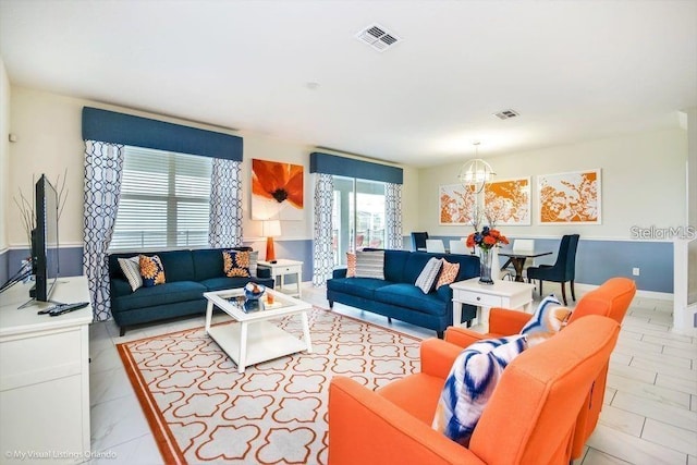 living room featuring visible vents and an inviting chandelier