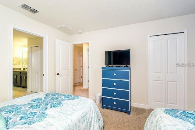 bedroom with visible vents, light carpet, a textured ceiling, a closet, and baseboards