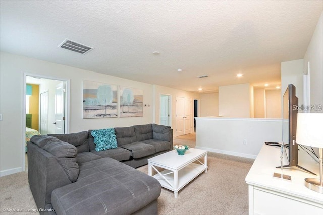 living area with light carpet, visible vents, a textured ceiling, and baseboards