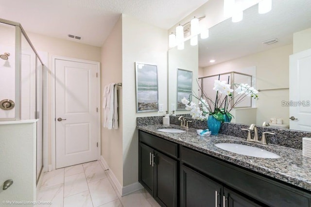 full bathroom with baseboards, visible vents, a stall shower, and a sink