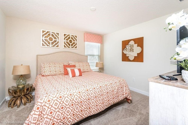 bedroom with baseboards, carpet, and a textured ceiling