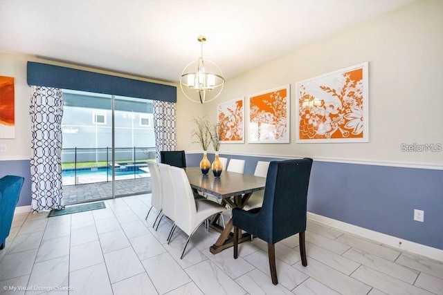 dining area with baseboards and a chandelier