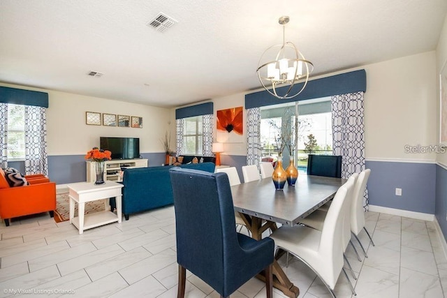 dining area featuring visible vents, baseboards, a notable chandelier, and marble finish floor