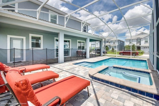 view of swimming pool with a patio, an in ground hot tub, and a lanai