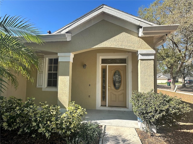 entrance to property featuring stucco siding