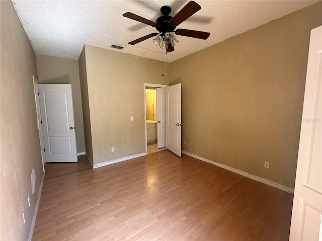 unfurnished bedroom featuring visible vents, baseboards, light wood-type flooring, a textured ceiling, and a ceiling fan