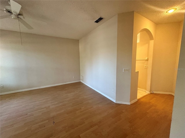 unfurnished room featuring visible vents, baseboards, ceiling fan, and wood finished floors