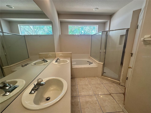 full bathroom with a sink, a garden tub, and a stall shower