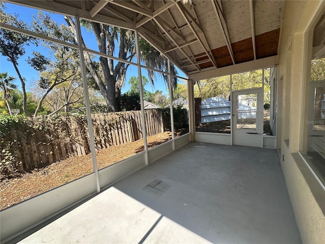 unfurnished sunroom featuring vaulted ceiling