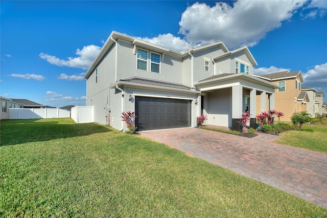 view of front of property featuring fence, a front yard, stucco siding, decorative driveway, and an attached garage